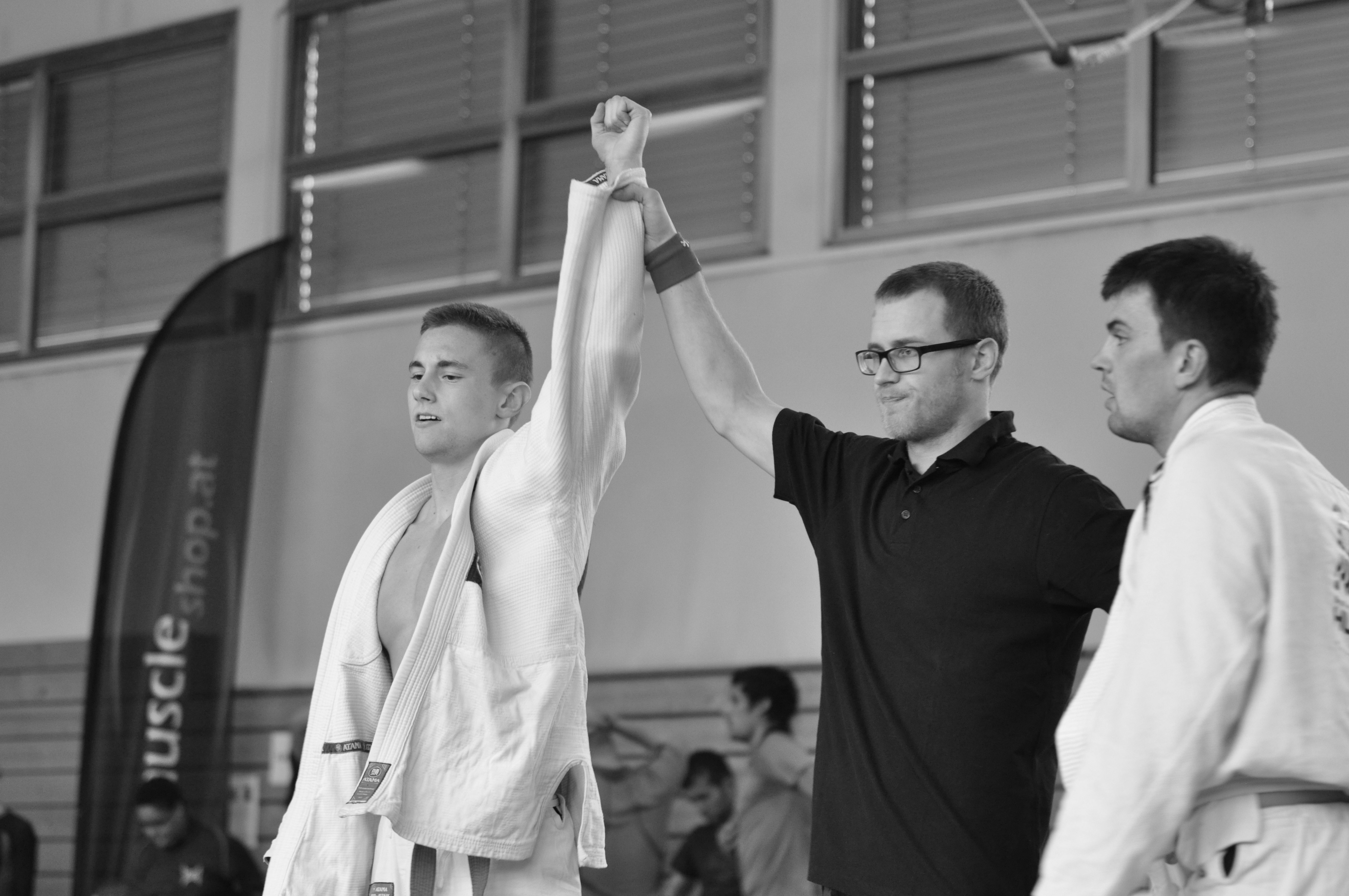 Sportler mit erhobenem Arm bei einer Siegerehrung.
