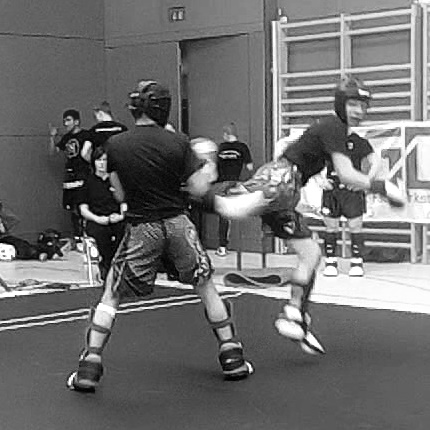 Zwei Sportler beim Kickboxen im Ring.