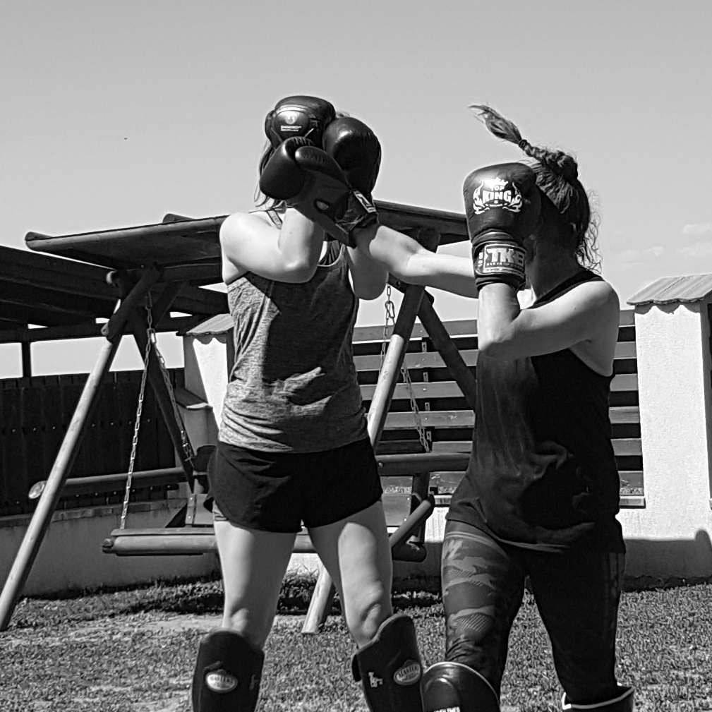 Partnerübung mit Boxhandschuhen im Freien.