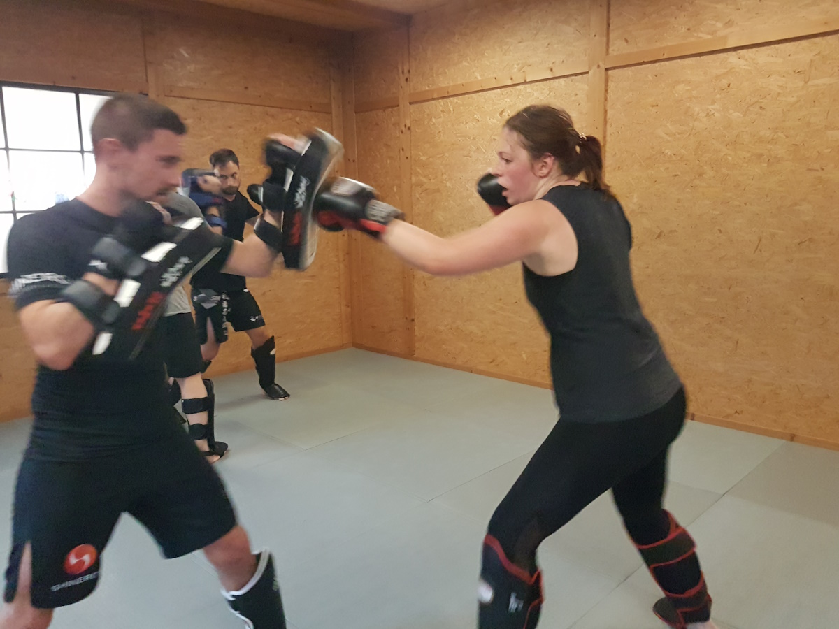 Schlagtraining an Pratzen im Kickbox-Workout.