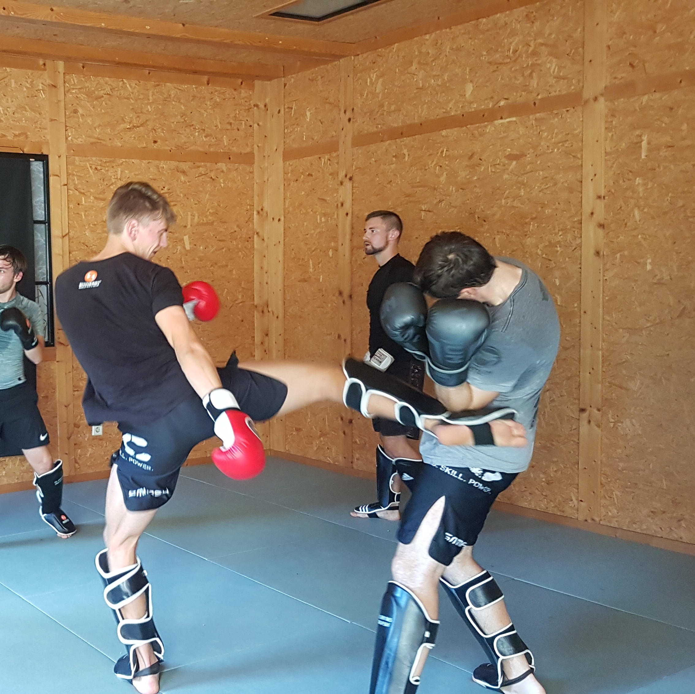 Partnerübung mit Schutzausrüstung beim Kickboxen.